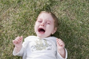 Child Crying and Lying on Grass